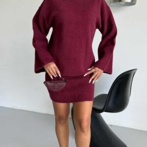 целосен изглед на модел во широк бордо џемпер и плетен комплет со бели сандали