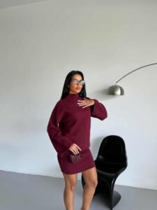 крупен кадар на женски плетен комплет оверсајз ролка и мини здолниште во бордо боја