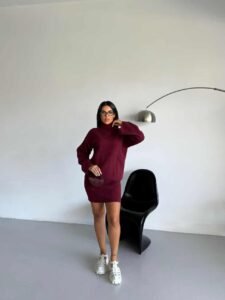 модерна комбинација на плетена ролка и здолниште, модел позира до црно столче